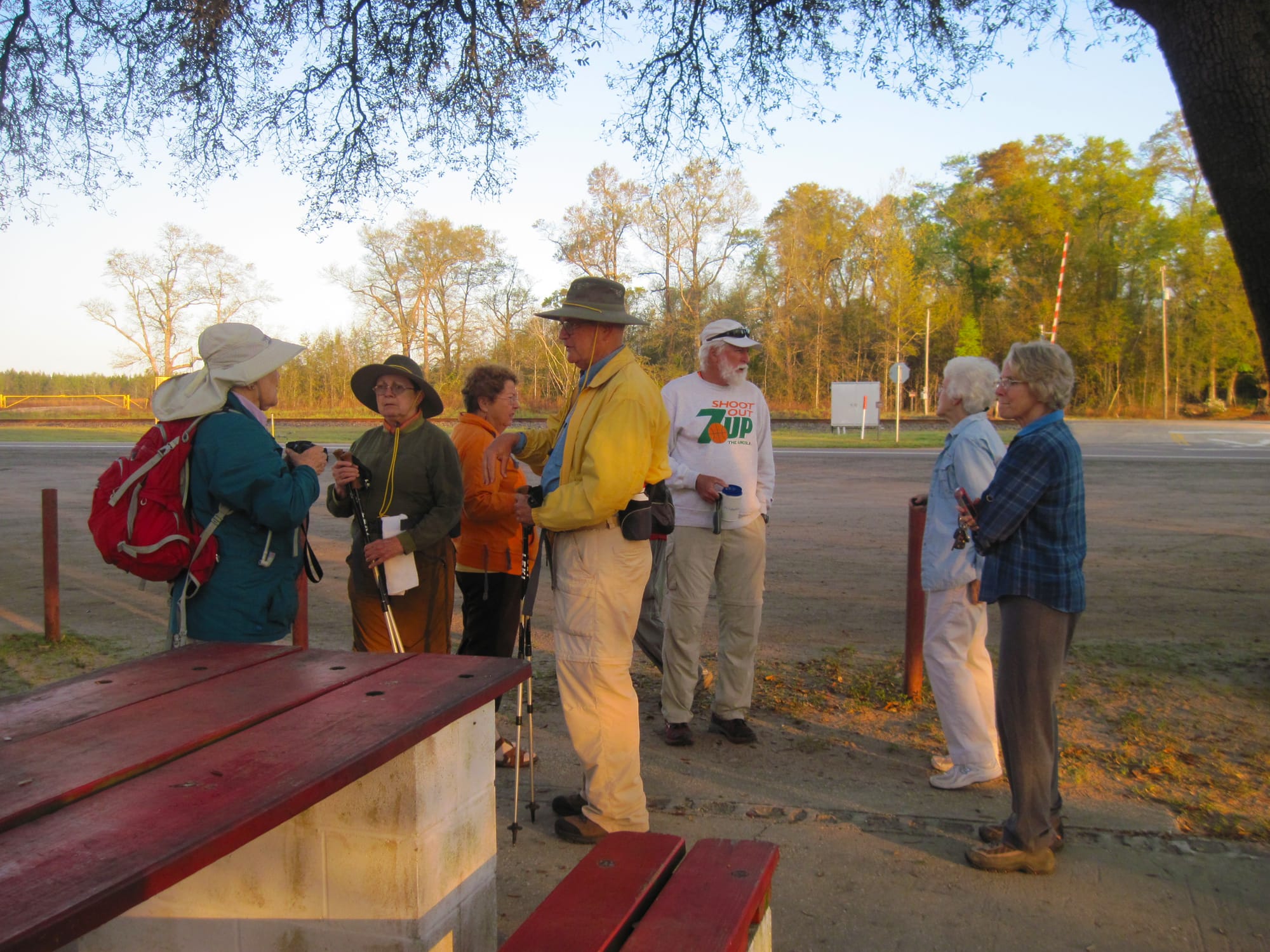 Group of hikers in early morning light by a picnic table