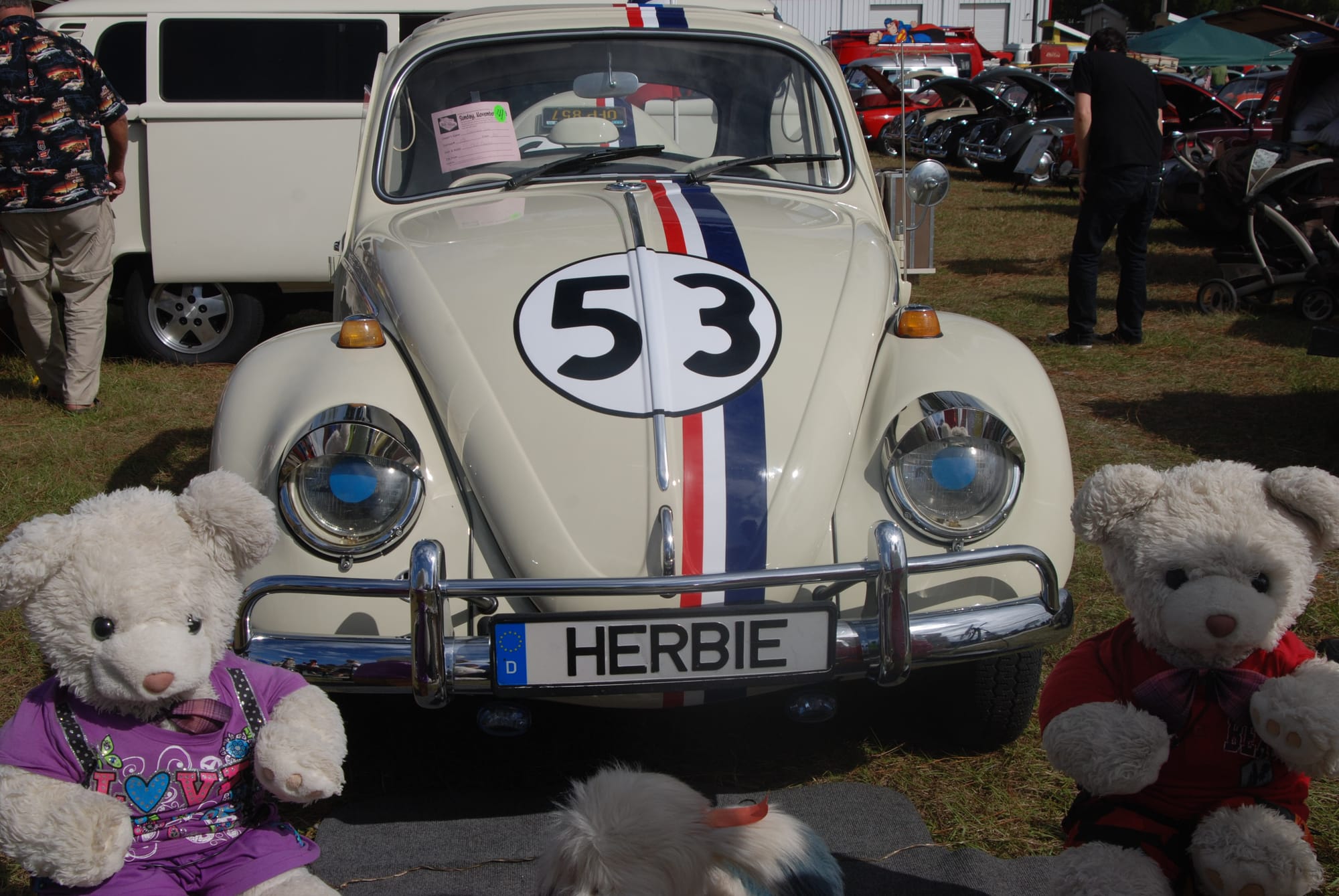 VW Beetle with racing stripes and 53 painted in circle, flanked by teddy bears