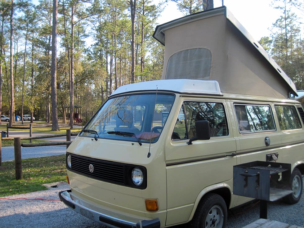 VW camper with top popped in campsite