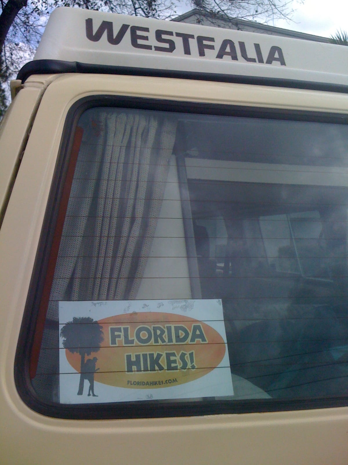 Back window of camper van with Florida Hikes sign in it