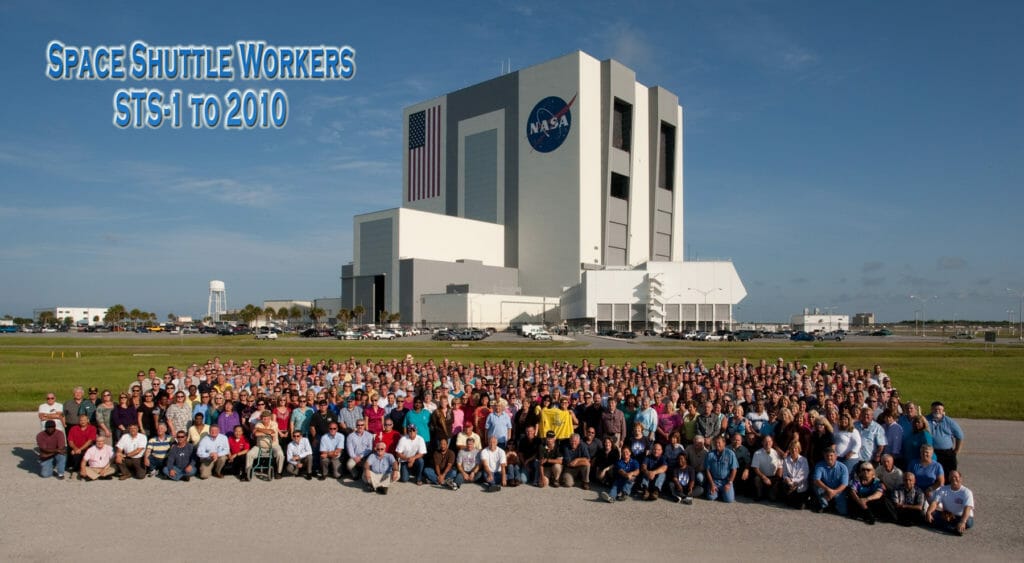 Group photo of Space Shuttle workers through 2010 with VAB in background