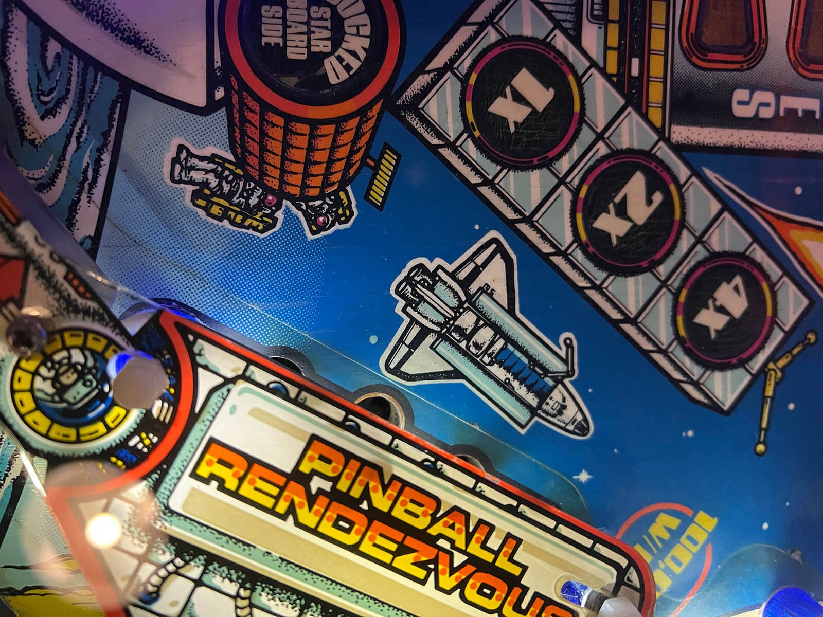 Space-themed pinball art on a playing field