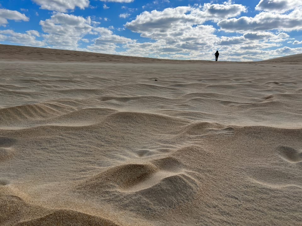 Woman's silhoutte atop a sand dune