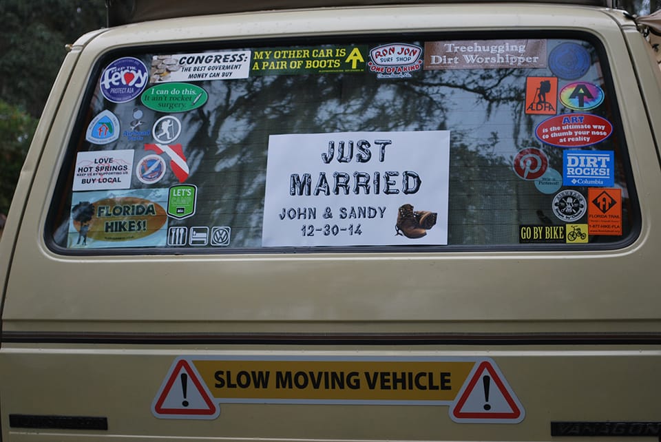 Just Married sign in Westfalia back window among many stickers